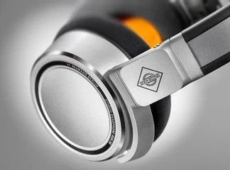 Neumann Closed-back studio headphone, silver with black and orange trim. Includes (1) NDH 20, (1) straight cable, (1) coiled cable, (1) 6.3mm (1/4") adapter, and (1) cloth pouch